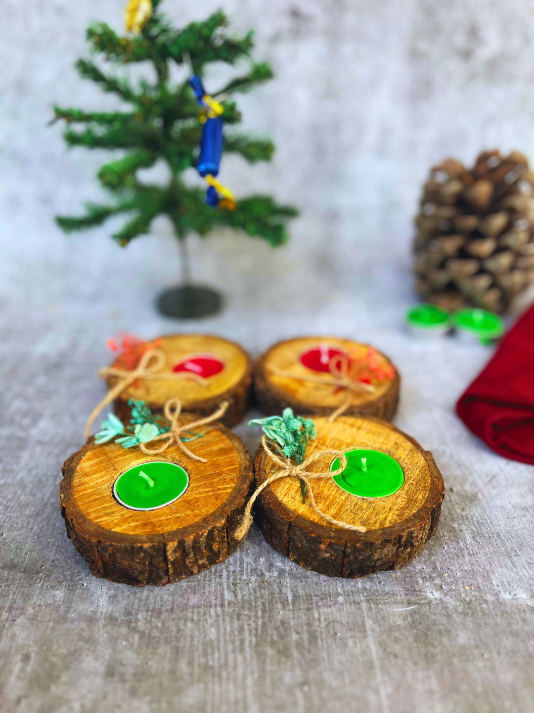 Set of 4 handcrafted wooden log tealight holders in festive red and evergreen colors with dried flower accents